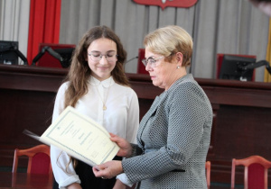 Uczennica odbiera stypendium.