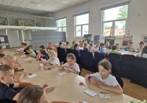 Uczniowie biorą udział w warsztatach - wycinanki łowickie.