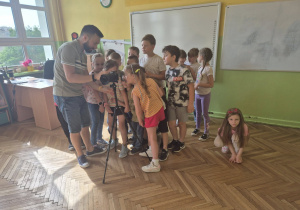 Dzieci oglądają wykonane fotografie.