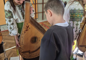 Uczniowie poznają nowy instrument - bandurę.