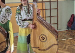 Członek zespołu prezentuje bandurę.