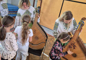 Uczniowie poznają nowy instrument - bandurę.