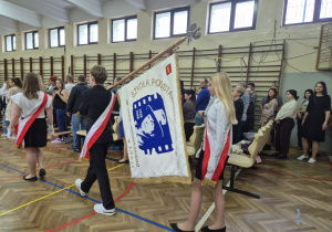 Uczniowie wnoszą sztandar szkoły.