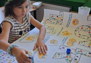 Uczennica wykonuje plakat.