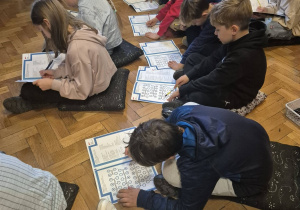 Dzieci wykonują zadania w ćwiczeniach.