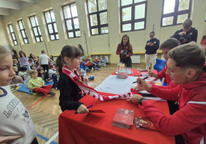 Piłkarze rozdają autografy.