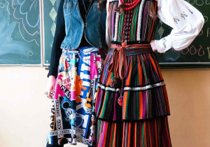 Na zdjęciu Maria i Ewa, uczennice XXI Liceum w Łodzi, które prowadziły warsztaty o kulturze słowiańskiej. Maria, po prawej ubrana jest w tradycyjny ludowy strój opoczyński. Ewa, stojąca po lewej, ubrana jest w kolorową spódnicę, czarną bluzkę, dżinsową kamizelkę, a na głowie ma wianek z kwiatów.