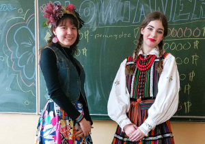 Na zdjęciu Maria i Ewa, uczennice XXI Liceum w Łodzi, które prowadziły warsztaty o kulturze słowiańskiej. Maria, po prawej ubrana jest w tradycyjny ludowy strój opoczyński. Ewa, stojąca po lewej, ubrana jest w kolorową spódnicę, czarną bluzkę, dżinsową kamizelkę, a na głowie ma wianek z kwiatów.